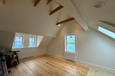 Inspiration for a large contemporary open concept light wood floor and vaulted ceiling living room library remodel in Portland Maine with white walls