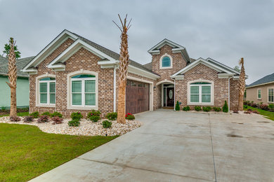 Mid-sized elegant brown two-story brick exterior home photo in Other with a shingle roof