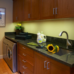 Inspiration for a classic utility room in San Francisco with a single-bowl sink, medium wood cabinets, granite worktops, yellow walls, bamboo flooring and a side by side washer and dryer.