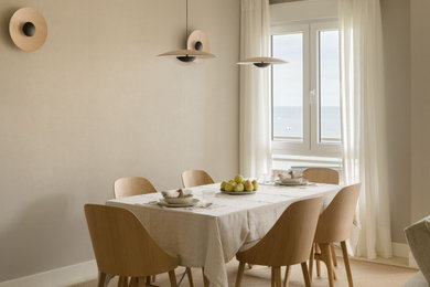 Modelo de comedor clásico renovado de tamaño medio abierto sin chimenea con paredes beige, suelo laminado, papel pintado y alfombra