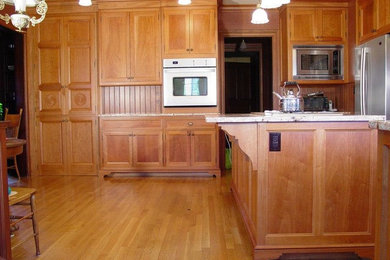 Example of an arts and crafts kitchen design in Providence with medium tone wood cabinets and stainless steel appliances