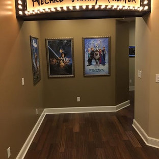 Home theater - large modern open concept medium tone wood floor home theater idea in Cleveland with beige walls and a projector screen
