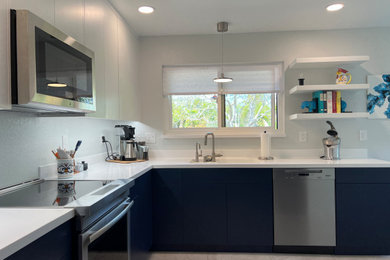 Mid-sized minimalist laminate floor and multicolored floor eat-in kitchen photo in Santa Barbara with an integrated sink, flat-panel cabinets, blue cabinets, white countertops, quartzite countertops, stainless steel appliances and no island