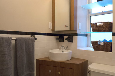 Alcove bathtub - small contemporary white tile and ceramic tile mosaic tile floor alcove bathtub idea in New York with a vessel sink, furniture-like cabinets, medium tone wood cabinets, a two-piece toilet and beige walls