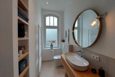 Design ideas for a mid-sized traditional 3/4 bathroom in Dusseldorf with flat-panel cabinets, brown cabinets, a curbless shower, a two-piece toilet, beige tile, stone tile, beige walls, ceramic floors, a vessel sink, solid surface benchtops, beige floor, an open shower, brown benchtops, a single vanity and a freestanding vanity.