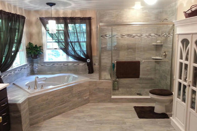 Photo of a large transitional master bathroom in Baltimore with dark wood cabinets, engineered quartz benchtops, gray tile, porcelain tile, a drop-in tub, a two-piece toilet, an undermount sink, beige walls, porcelain floors and a corner shower.
