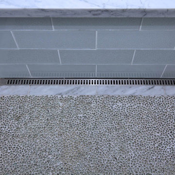 Glass and Carrara Marble shower with linear drain and recycle glass pebble floor