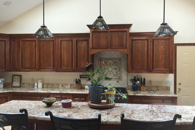 Eat-in kitchen - mid-sized craftsman l-shaped light wood floor and beige floor eat-in kitchen idea in New York with an undermount sink, recessed-panel cabinets, dark wood cabinets, granite countertops, black appliances and an island