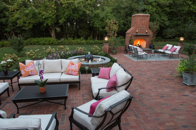 Large traditional backyard patio in St Louis with a fire feature and brick pavers.