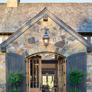 Выдающиеся фото от архитекторов и дизайнеров интерьера: прихожая в стиле кантри с коричневыми стенами, полом из известняка, двустворчатой входной дверью, входной дверью из дерева среднего тона и коричневым полом