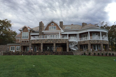 Example of a large arts and crafts brown two-story mixed siding house exterior design in Other with a hip roof