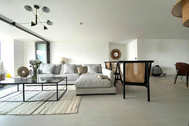 Example of an island style ceramic tile living room design in Other with white walls
