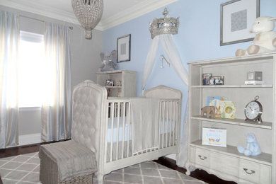 Small elegant boy dark wood floor nursery photo in Toronto with blue walls