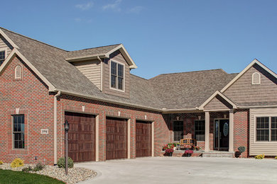 Example of a classic brown two-story brick exterior home design in Other with a shingle roof