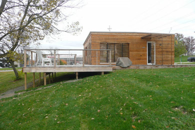 Cette photo montre une façade de maison marron craftsman en bois de taille moyenne et de plain-pied avec un toit plat.