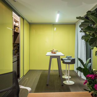 Small contemporary kitchen pantry designs - Example of a small trendy l-shaped dark wood floor and brown floor kitchen pantry design in Stuttgart with flat-panel cabinets, green cabinets, paneled appliances and an island