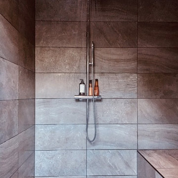 Badrum med walk-in shower, ångbad, snedtak och djupt takfönster.
