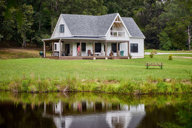 Example of a small farmhouse white exterior home design in Other with a shingle roof