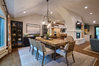 Dining room - large contemporary medium tone wood floor, brown floor and exposed beam dining room idea in Denver with gray walls, a two-sided fireplace and a brick fireplace