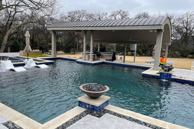 Example of a mid-sized backyard stamped concrete and rectangular hot tub design in Dallas