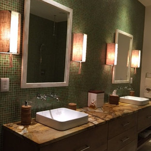 Idee per una grande stanza da bagno padronale tropicale con ante lisce, ante marroni, vasca da incasso, doccia ad angolo, piastrelle verdi, piastrelle a mosaico, pareti verdi, pavimento in pietra calcarea, lavabo rettangolare, top in onice, pavimento beige e doccia aperta
