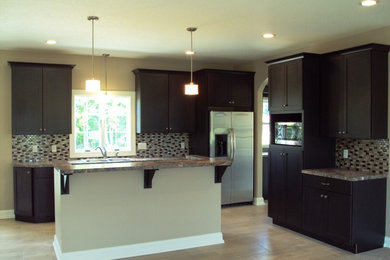Large transitional galley dark wood floor and brown floor open concept kitchen photo in Other with an undermount sink, shaker cabinets, white cabinets, quartz countertops, beige backsplash, stone tile backsplash, stainless steel appliances and an island