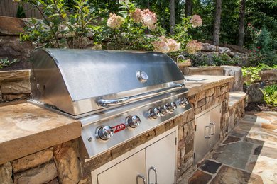 Example of a backyard stone patio kitchen design in Atlanta