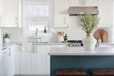 Imagen de cocina comedor marinera con armarios estilo shaker, puertas de armario blancas y una isla