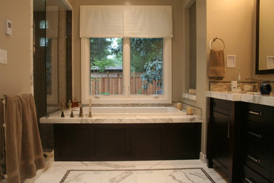 Design ideas for a large traditional master bathroom in San Francisco with an undermount sink, recessed-panel cabinets, brown cabinets, marble benchtops, a drop-in tub, a double shower, white tile, stone slab, beige walls and marble floors.