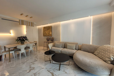 Cette photo montre un salon tendance de taille moyenne et ouvert avec un bar de salon, un mur beige, un sol en marbre, un téléviseur encastré, un sol beige, un plafond décaissé, un mur en pierre et éclairage.