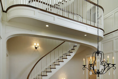 Large elegant u-shaped wood railing staircase photo in Chicago with painted risers
