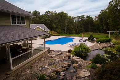 Inspiration for a large craftsman backyard custom-shaped pool remodel in Philadelphia with decking