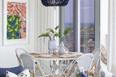 Beach style dining room in Miami with white walls and white floor.