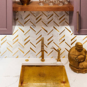 Hammered brass sink and marble backsplash