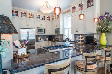 Elegant u-shaped light wood floor eat-in kitchen photo in Miami with a farmhouse sink, shaker cabinets, white cabinets, blue backsplash, stainless steel appliances, a peninsula, marble countertops and subway tile backsplash