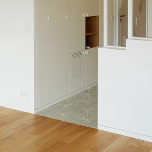 パリの小さい片開きドアコンテンポラリースタイルのおしゃれな玄関ホール (白い壁、白いドア、セラミックタイルの床、ターコイズの床) の写真