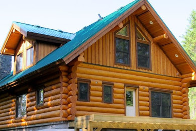 Inspiration for a mid-sized rustic brown three-story wood exterior home remodel in Other with a metal roof