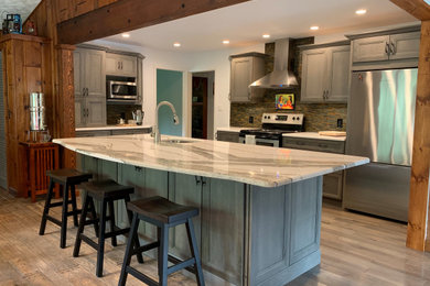 Example of an eat-in kitchen design with a single-bowl sink, flat-panel cabinets, gray cabinets, quartz countertops and an island