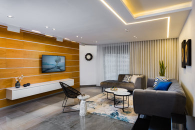 Imagen de salón abierto minimalista de tamaño medio con paredes beige, suelo de baldosas de cerámica, televisor colgado en la pared, suelo gris y madera
