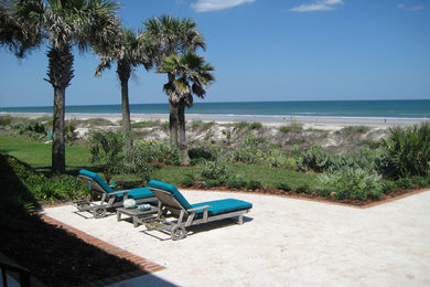 This is an example of a mid-sized beach style backyard patio in Jacksonville with concrete slab.