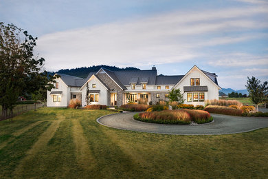 Example of a country white two-story exterior home design in Vancouver with a metal roof