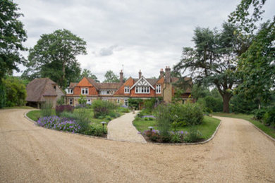 This is an example of a classic front driveway full sun garden in Surrey with gravel.