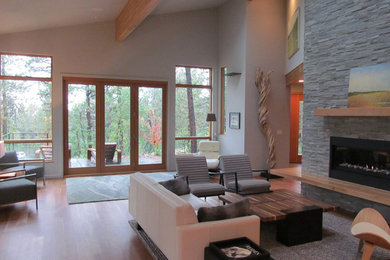 Huge trendy open concept medium tone wood floor and brown floor living room photo in Albuquerque with white walls, a ribbon fireplace and a stone fireplace