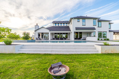 Example of a large transitional beige two-story stucco exterior home design in Houston with a mixed material roof