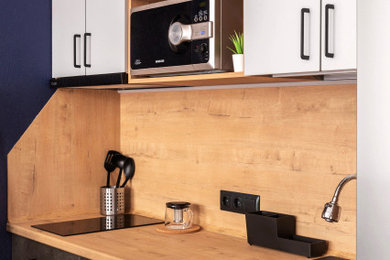 На фото: маленькая прямая кухня в современном стиле с обеденным столом, плоскими фасадами, серыми фасадами и островом с
