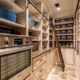 Traditional kitchen pantry remodeling - Example of a classic u-shaped kitchen pantry design in Austin with raised-panel cabinets, beige cabinets and stainless steel appliances