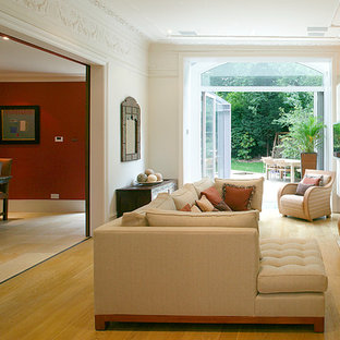 Inredning av ett modernt vardagsrum, med beige väggar, mellanmörkt trägolv och gult golv