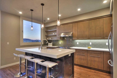 Eat-in kitchen - mid-sized modern galley dark wood floor eat-in kitchen idea in San Francisco with a farmhouse sink, flat-panel cabinets, light wood cabinets, quartz countertops, gray backsplash, subway tile backsplash, stainless steel appliances and an island