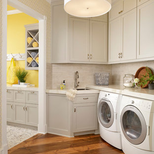 Design ideas for a small traditional separated utility room in Houston with an utility sink, shaker cabinets, grey cabinets, medium hardwood flooring, a side by side washer and dryer and yellow walls.