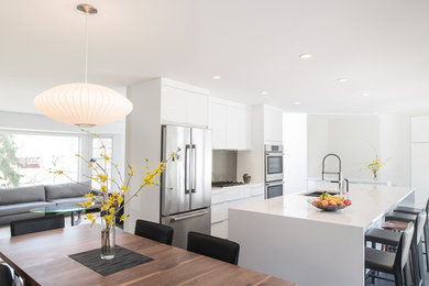 Inspiration for a mid-sized modern galley eat-in kitchen in Minneapolis with a double-bowl sink, flat-panel cabinets, white cabinets, quartz benchtops, grey splashback, glass sheet splashback, stainless steel appliances, porcelain floors and with island.